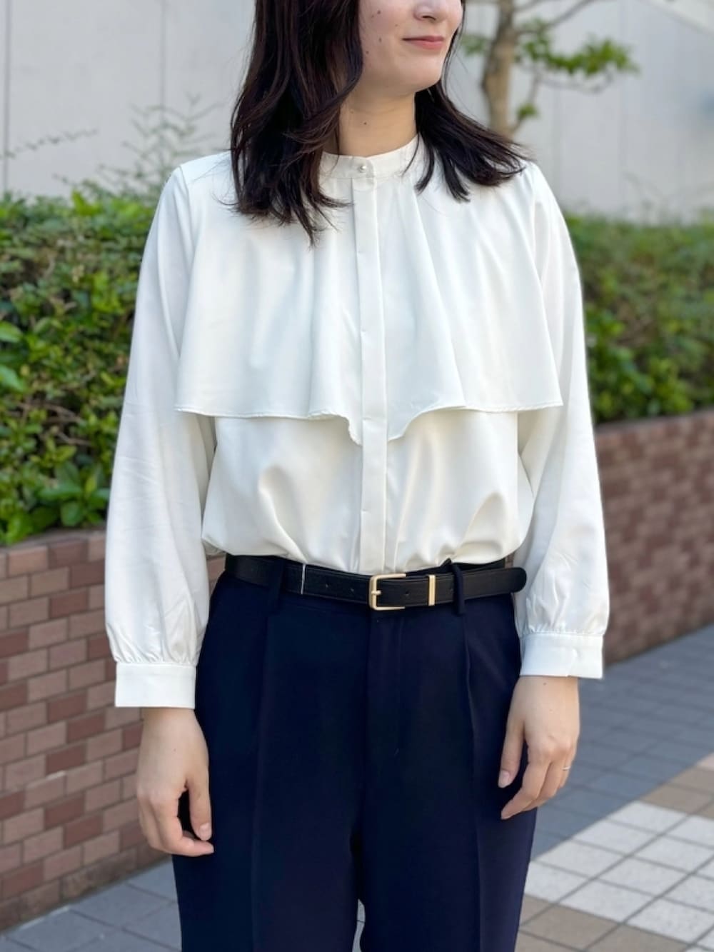 ホワイト系のシャツ/ブラウス、ブルー系のスラックスを着用したレディースの秋コーディネートの2枚目の写真