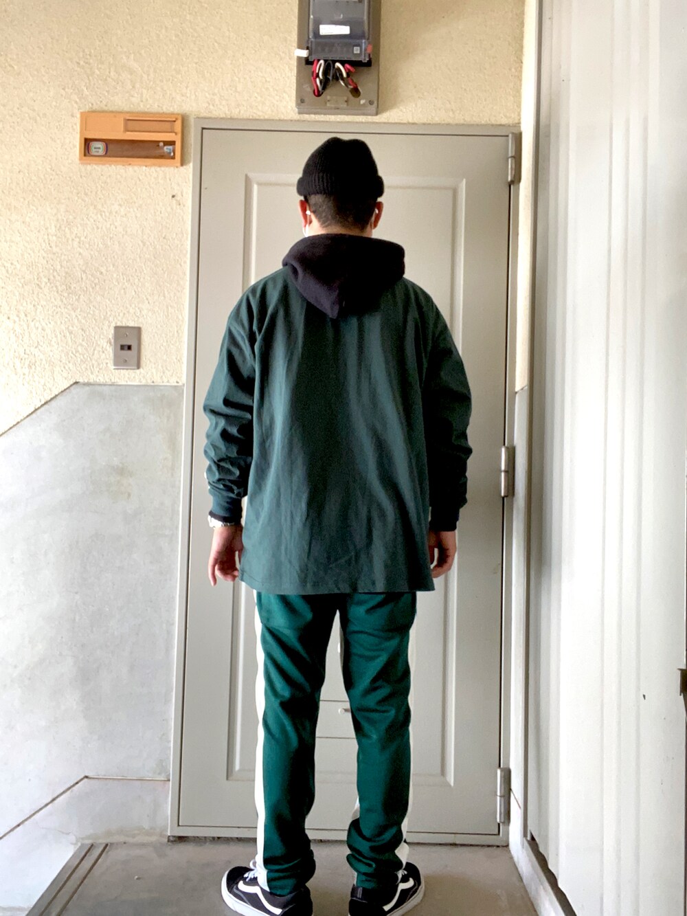 グリーン系のTシャツ/カットソー、ブラック系のパーカー、グリーン系のパンツを着用したメンズの冬コーディネートの2枚目の写真