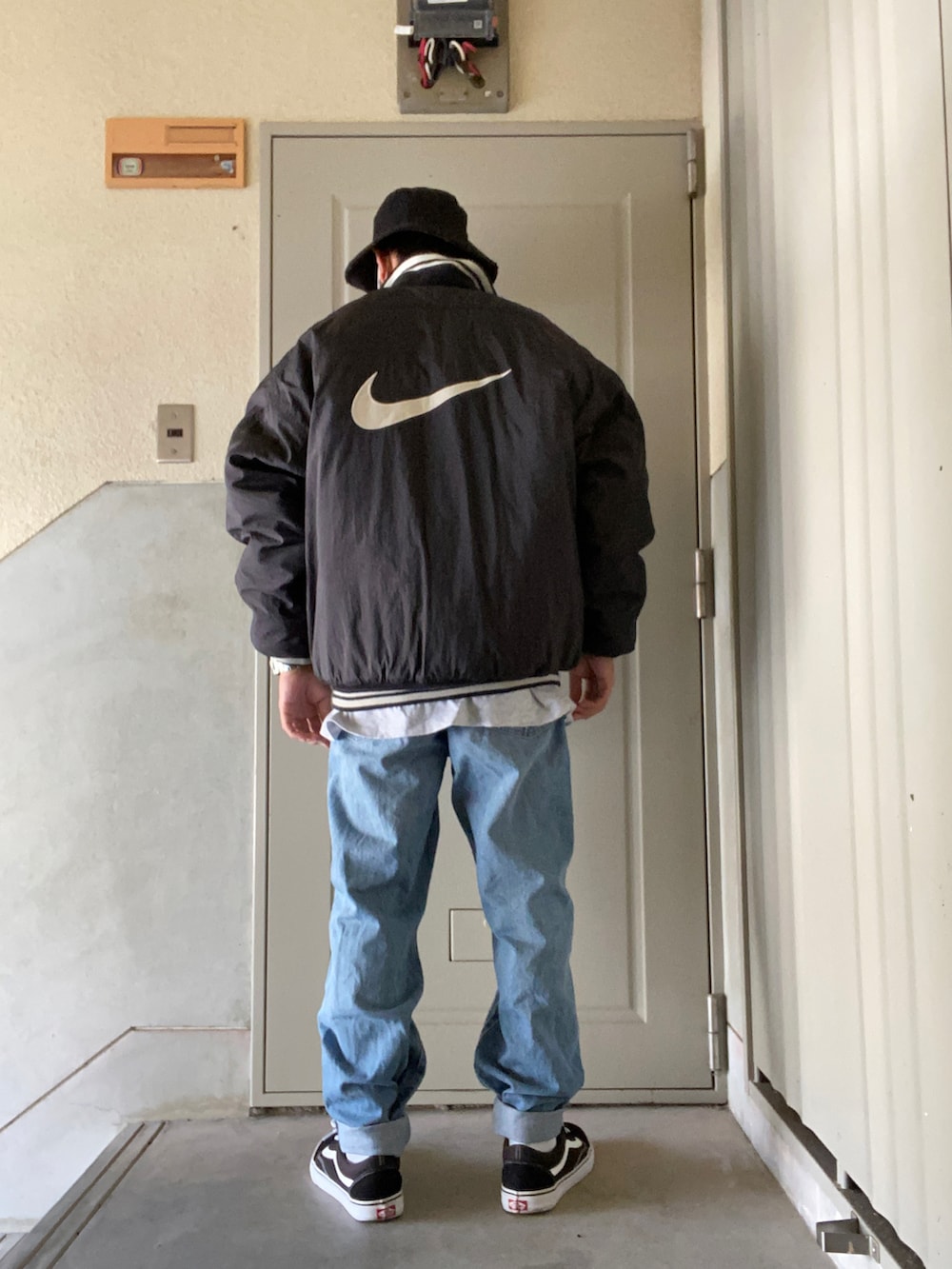 ブラック系のダウンジャケット/コート、グレー系のTシャツ/カットソー、ブラック系のスニーカーを着用したメンズの冬コーディネートの2枚目の写真