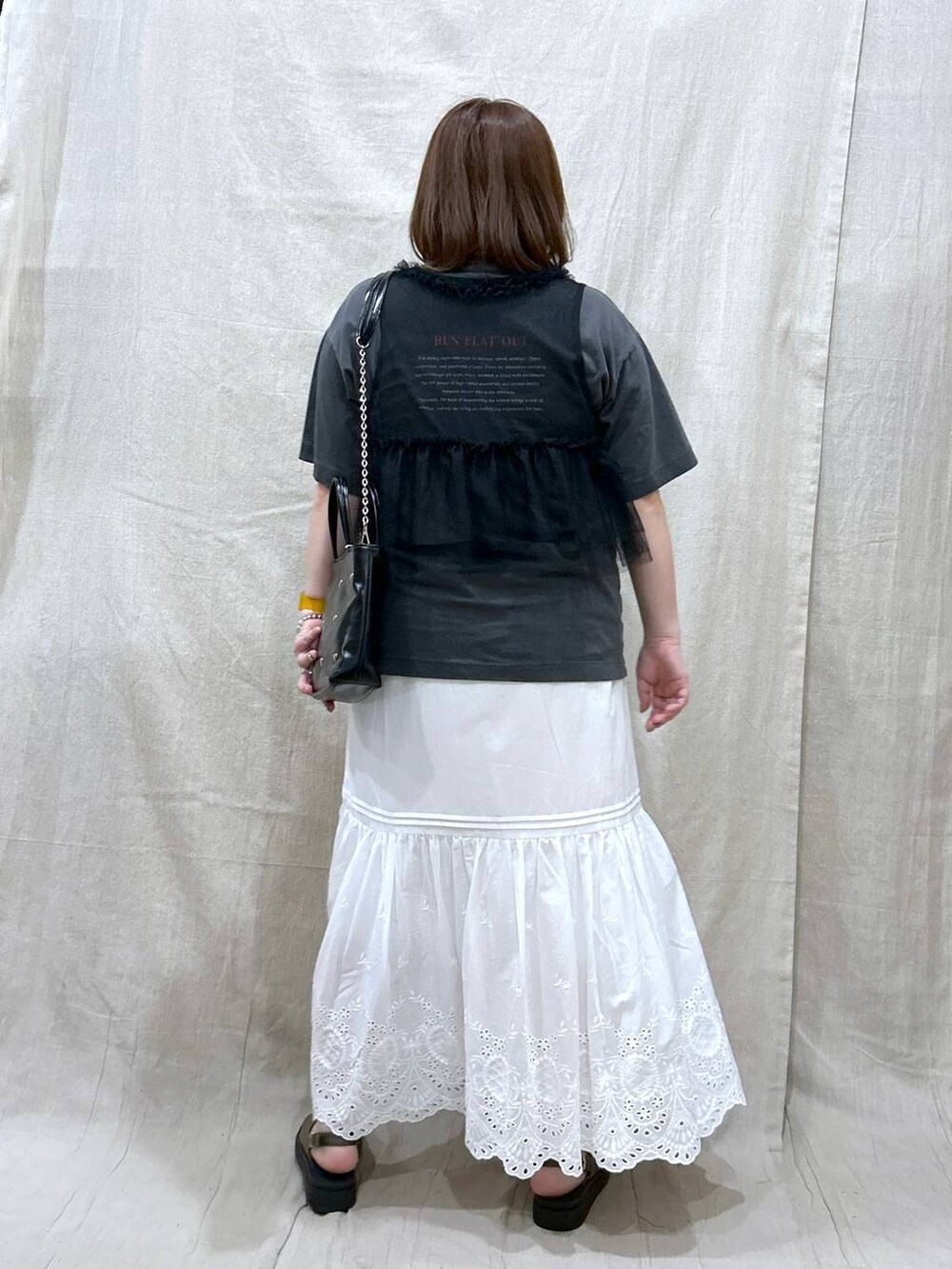 ホワイト系のスカート、グレー系のTシャツ/カットソー、グリーン系のサンダルを着用したレディースの夏コーディネートの5枚目の写真