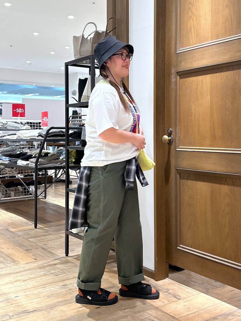 ブラック系のシャツ/ブラウス、グリーン系のその他パンツ、イエロー系のショルダーバッグを着用したレディースの春コーディネートの7枚目の写真