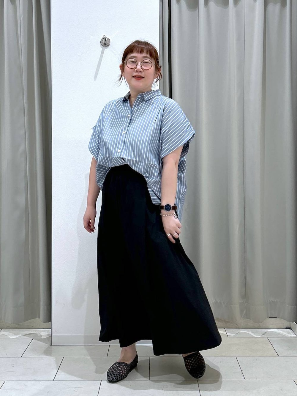 ブラック系のスカート、ブラック系のパンプス、ブルー系のシャツ/ブラウスを着用したレディースの夏コーディネートの2枚目の写真