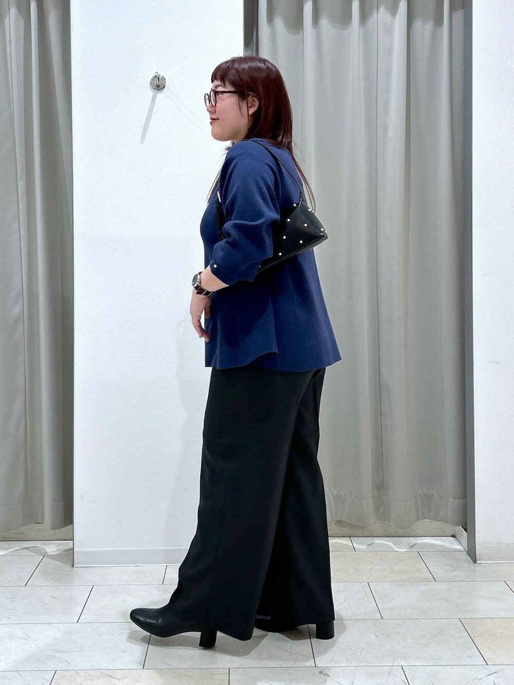 ブルー系のニット/セーター、ブラック系のその他パンツ、ブラック系のブーツを着用したレディースの秋コーディネートの3枚目の写真