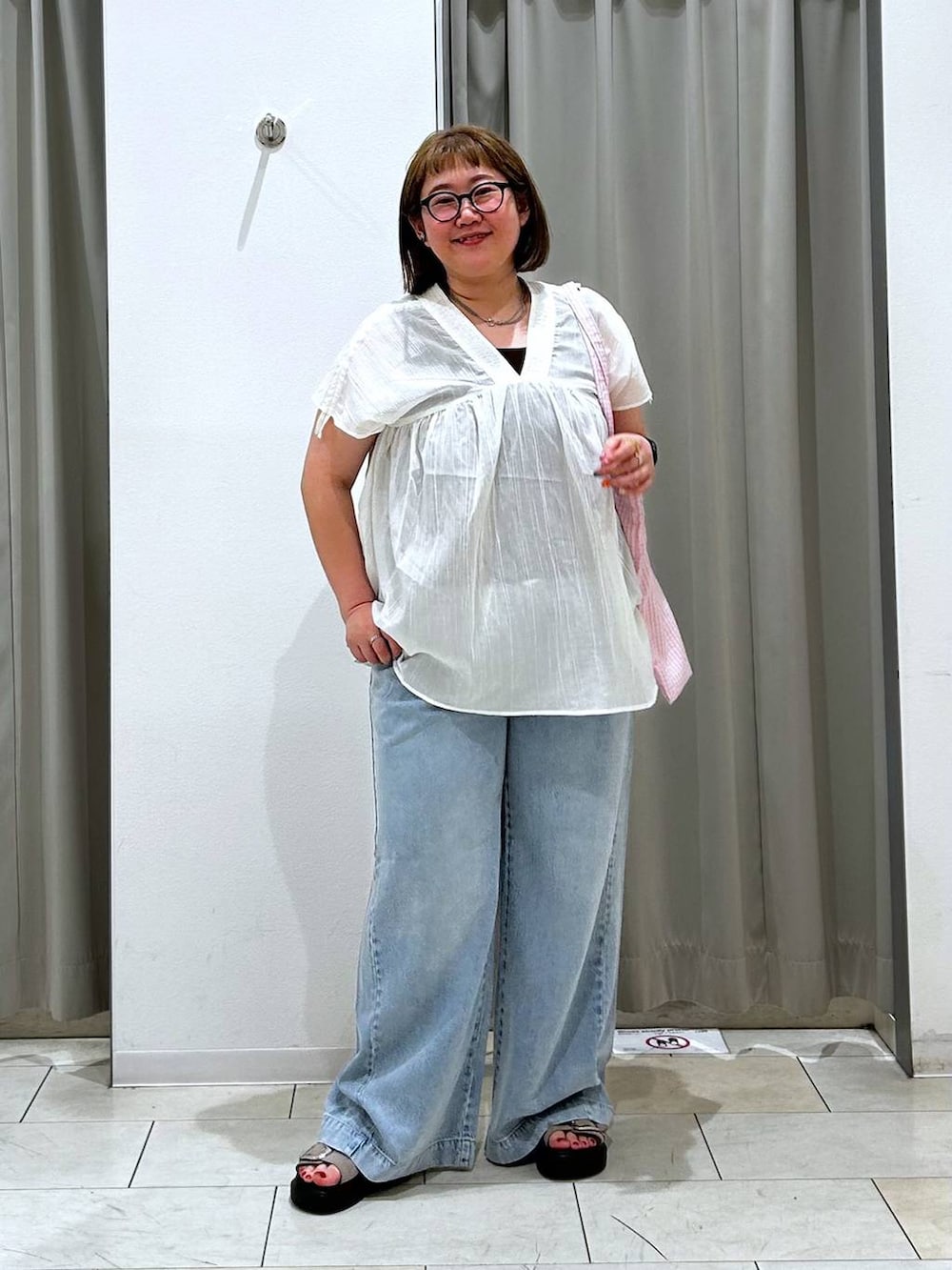 その他のトートバッグ、ブルー系のデニムパンツ、ブラウン系のタンクトップを着用したレディースの春コーディネートの3枚目の写真
