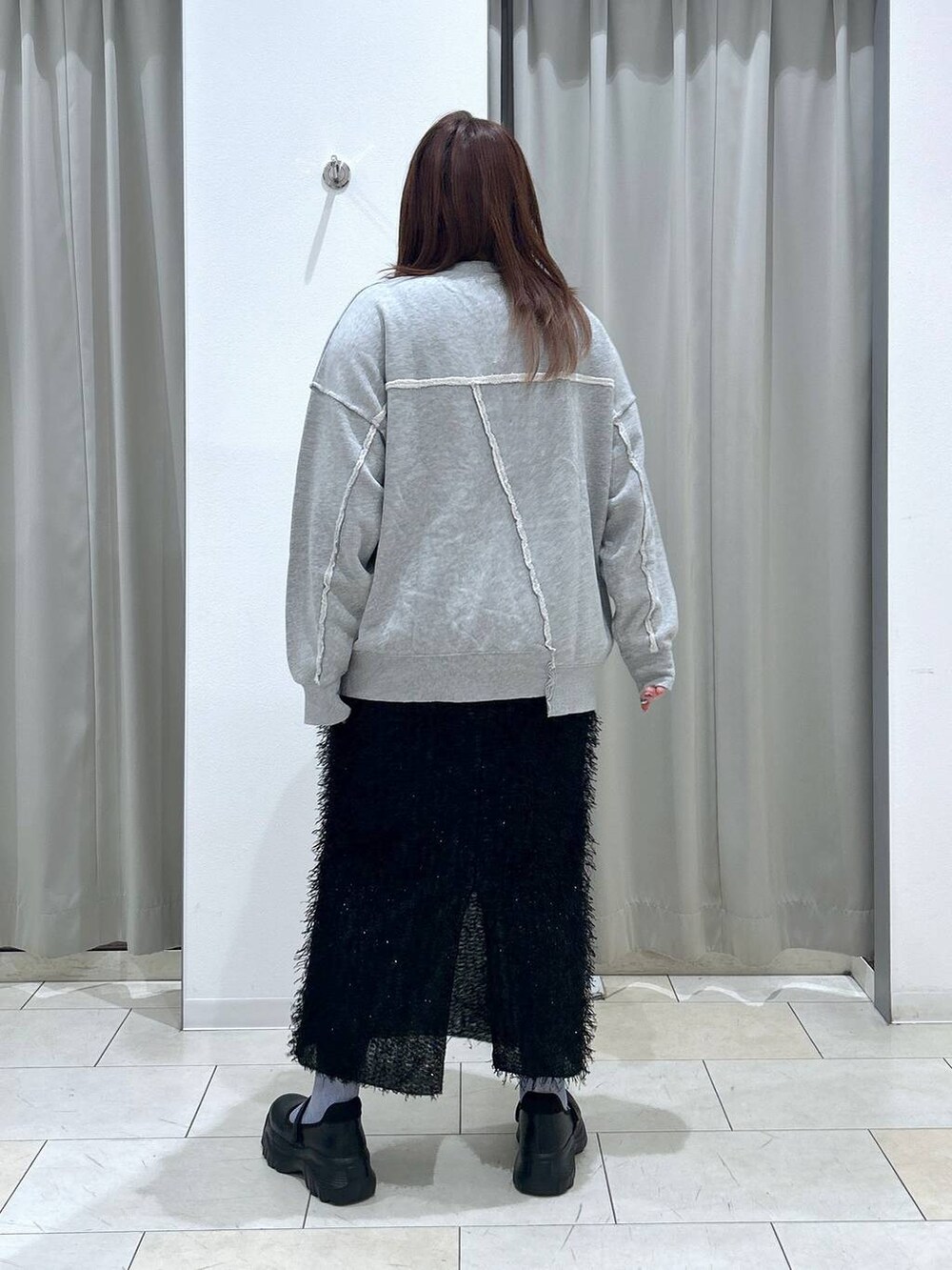 ブラック系のスニーカー、グレー系のスウェット、ブラック系のスカートを着用したレディースの秋コーディネートの4枚目の写真