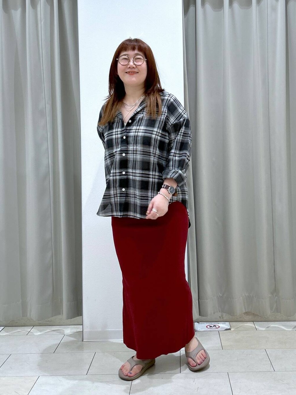 レッド系のスカート、ホワイト系のキャミソール、ベージュ系のサンダルを着用したレディースの夏コーディネートの4枚目の写真