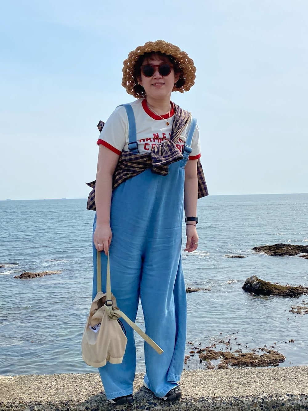 ホワイト系のTシャツ/カットソー、ブルー系のサロペット/オーバーオール、ベージュ系のショルダーバッグを着用したレディースの春コーディネートの2枚目の写真