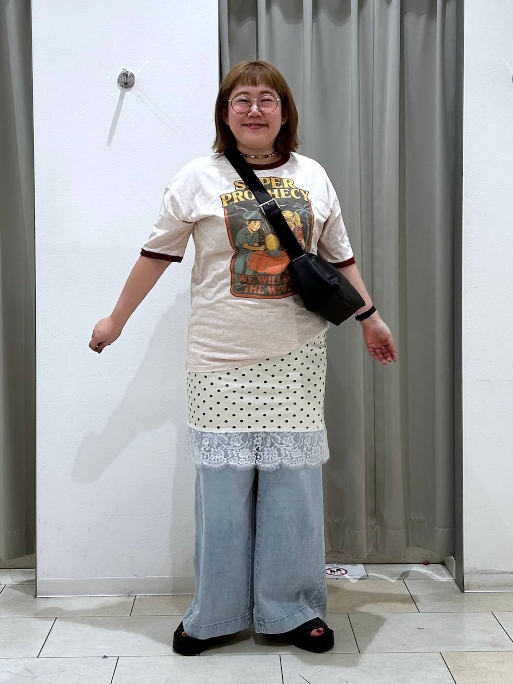 ブルー系のデニムパンツ、ブラック系のサンダル、ブラック系のショルダーバッグを着用したレディースの春コーディネートの2枚目の写真