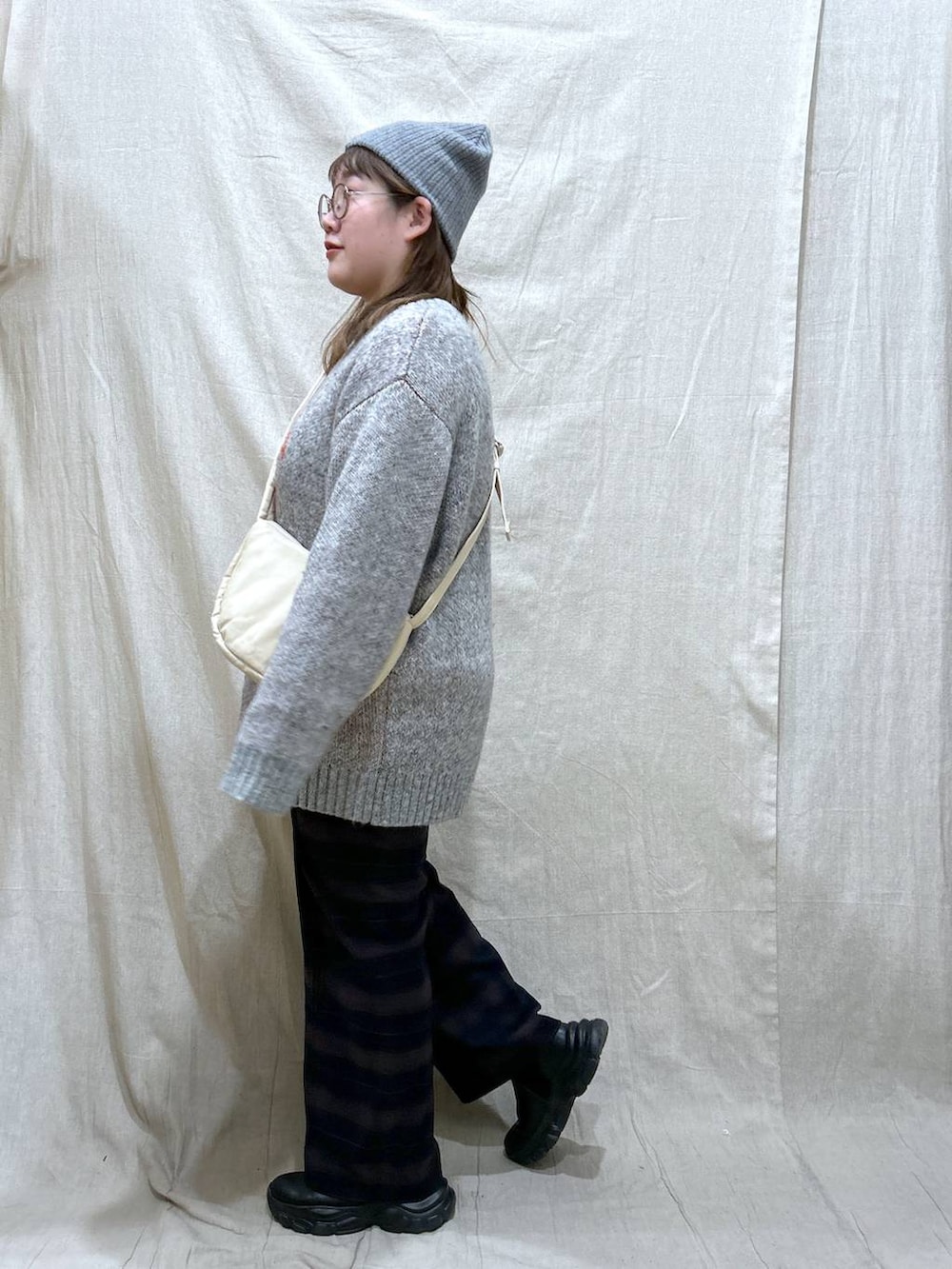 ホワイト系のショルダーバッグ、ブルー系のその他パンツ、ブラック系のブーツを着用したレディースの冬コーディネートの5枚目の写真