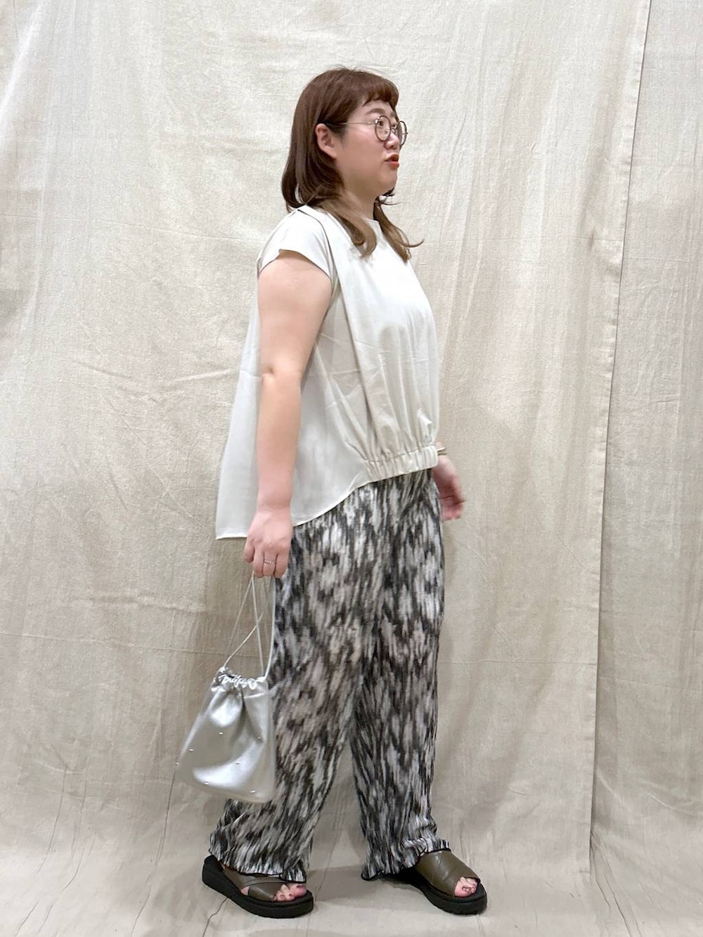 グリーン系のサンダル、シルバー系のショルダーバッグ、ブラック系のその他パンツを着用したレディースの夏コーディネートの7枚目の写真