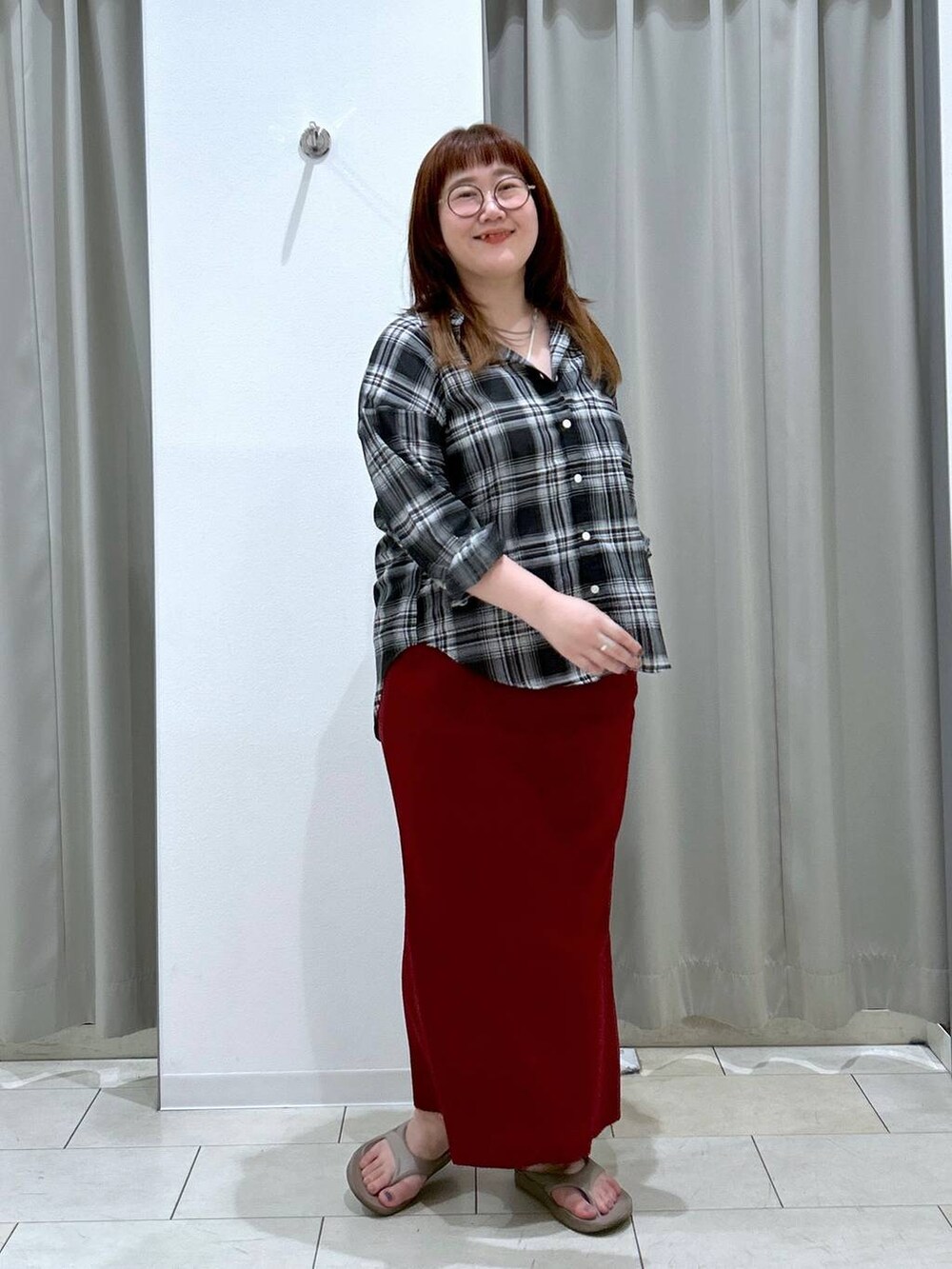 レッド系のスカート、ホワイト系のキャミソール、ベージュ系のサンダルを着用したレディースの夏コーディネートの2枚目の写真