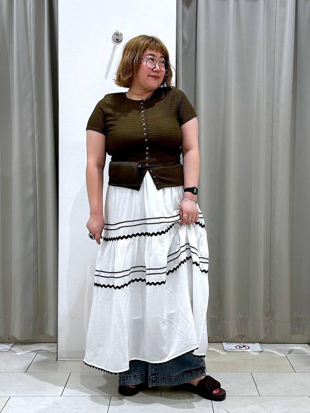 ブルー系のデニムパンツ、ブラウン系のボディバッグ/ウエストポーチ、ブラウン系のTシャツ/カットソーを着用したレディースの夏コーディネートの3枚目の写真