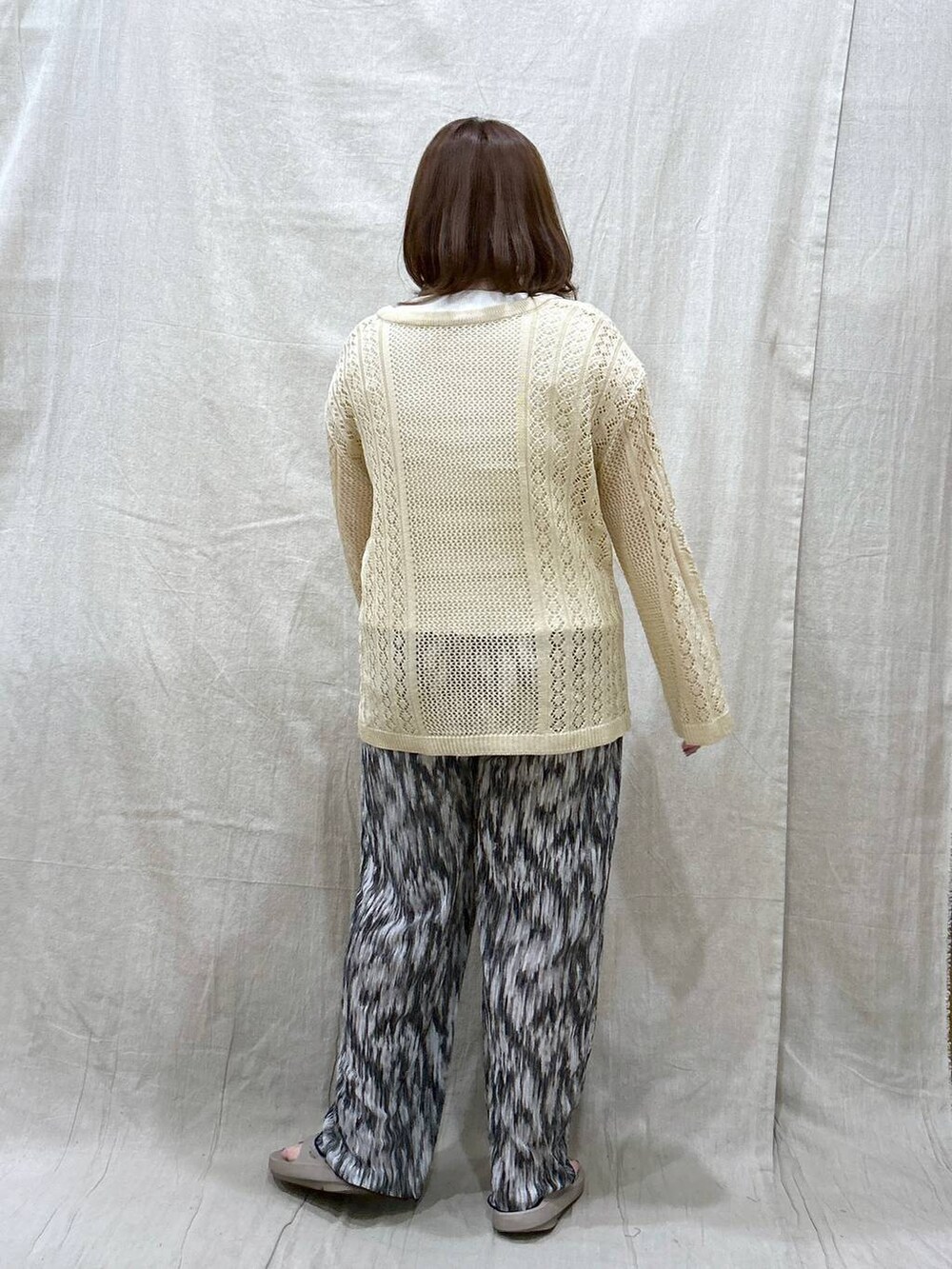 ホワイト系のニット/セーター、ブラック系のその他パンツ、ホワイト系のタンクトップを着用したレディースの夏コーディネートの6枚目の写真