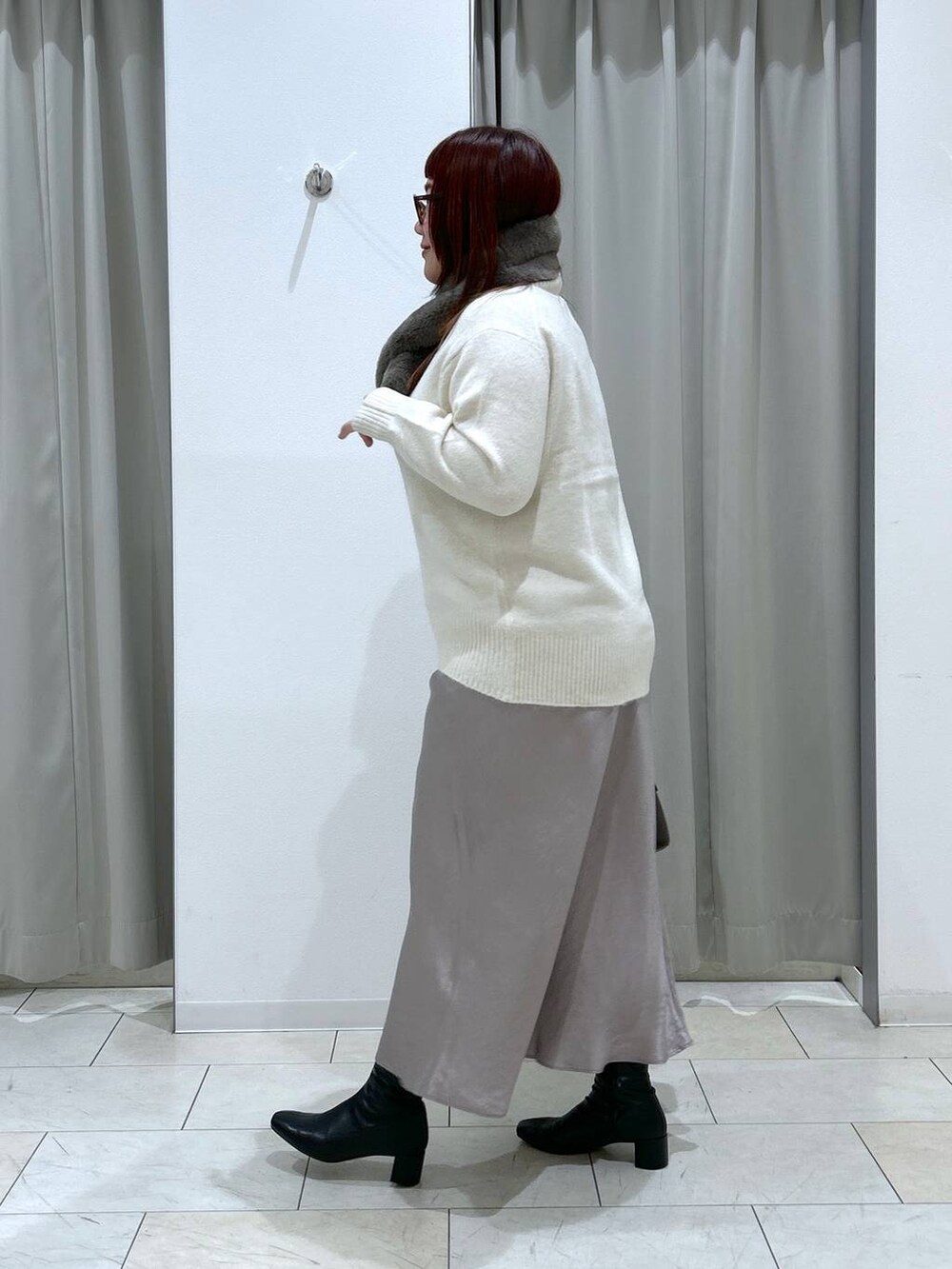 ホワイト系のニット/セーター、ブラック系のブーツ、ブラウン系のショルダーバッグを着用したレディースの冬コーディネートの4枚目の写真