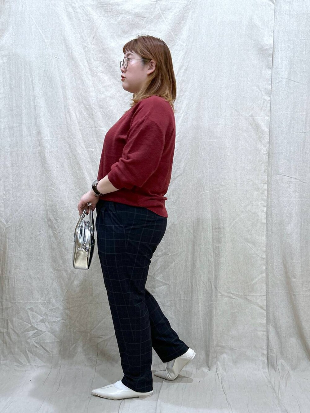 レッド系のニット/セーター、ブルー系のその他パンツ、ホワイト系のパンプスを着用したレディースの秋コーディネートの3枚目の写真