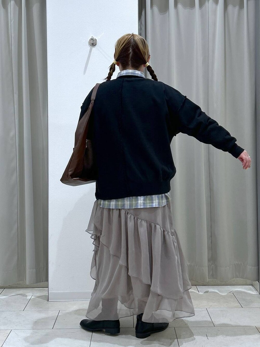 グリーン系のシャツ/ブラウス、ブラック系のブーツ、ブラウン系のトートバッグを着用したレディースの冬コーディネートの4枚目の写真