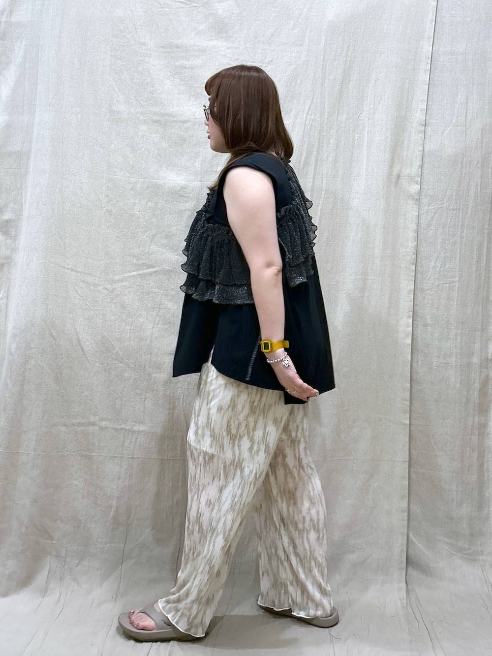 ベージュ系のその他パンツ、ベージュ系のサンダル、ブラック系のTシャツ/カットソーを着用したレディースの夏コーディネートの5枚目の写真