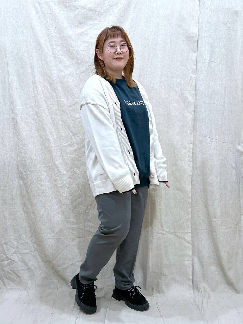 グレー系のその他パンツ、グリーン系のTシャツ/カットソー、ホワイト系のカーディガン/ボレロを着用したレディースの秋コーディネートの5枚目の写真