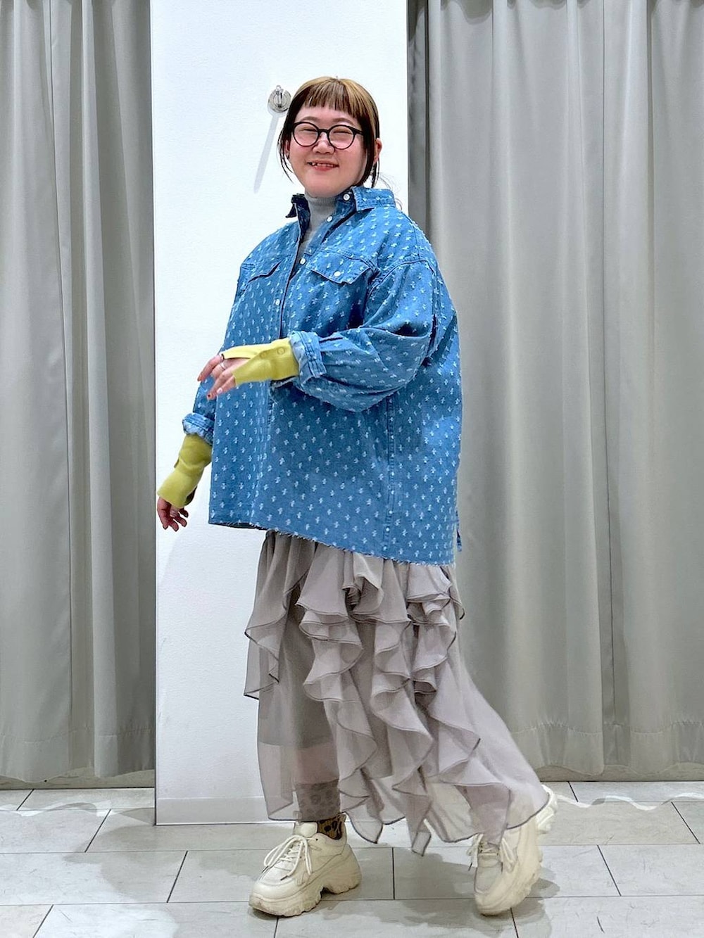 グレー系のニット/セーター、グレー系のスカート、ホワイト系のスニーカーを着用したレディースの冬コーディネートの3枚目の写真