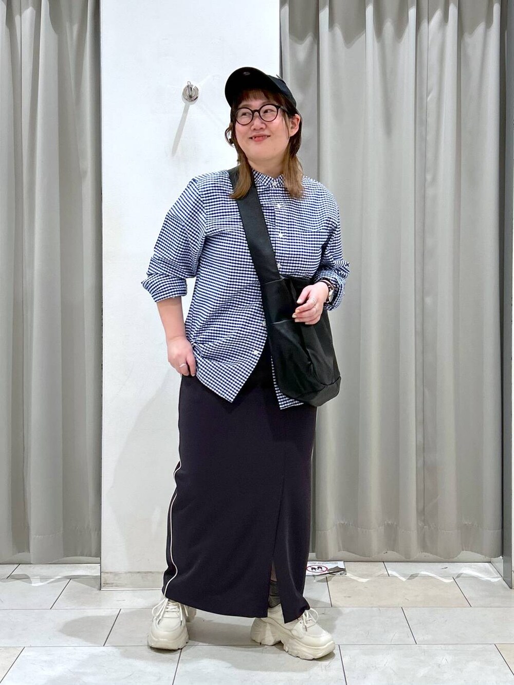 ブラック系のボディバッグ/ウエストポーチ、ホワイト系のスニーカー、グレー系のスカートを着用したレディースの冬コーディネートの2枚目の写真