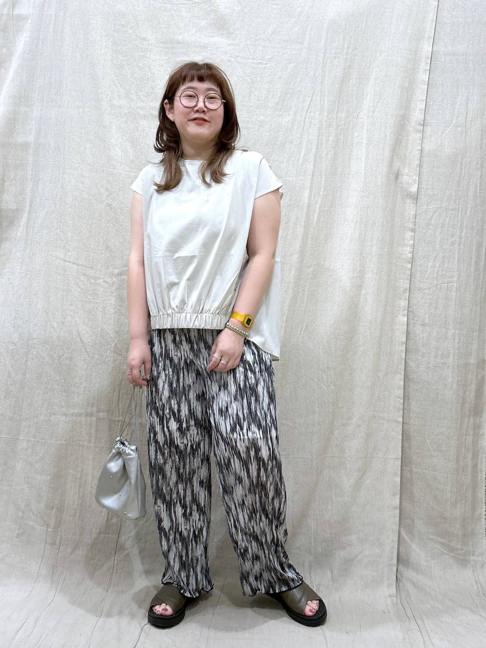 グリーン系のサンダル、シルバー系のショルダーバッグ、ブラック系のその他パンツを着用したレディースの夏コーディネートの3枚目の写真