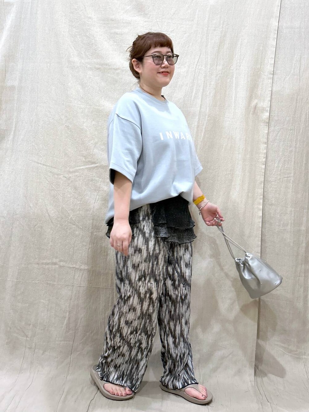 ホワイト系のショルダーバッグ、ベージュ系のサンダル、グリーン系のTシャツ/カットソーを着用したレディースの夏コーディネートの4枚目の写真