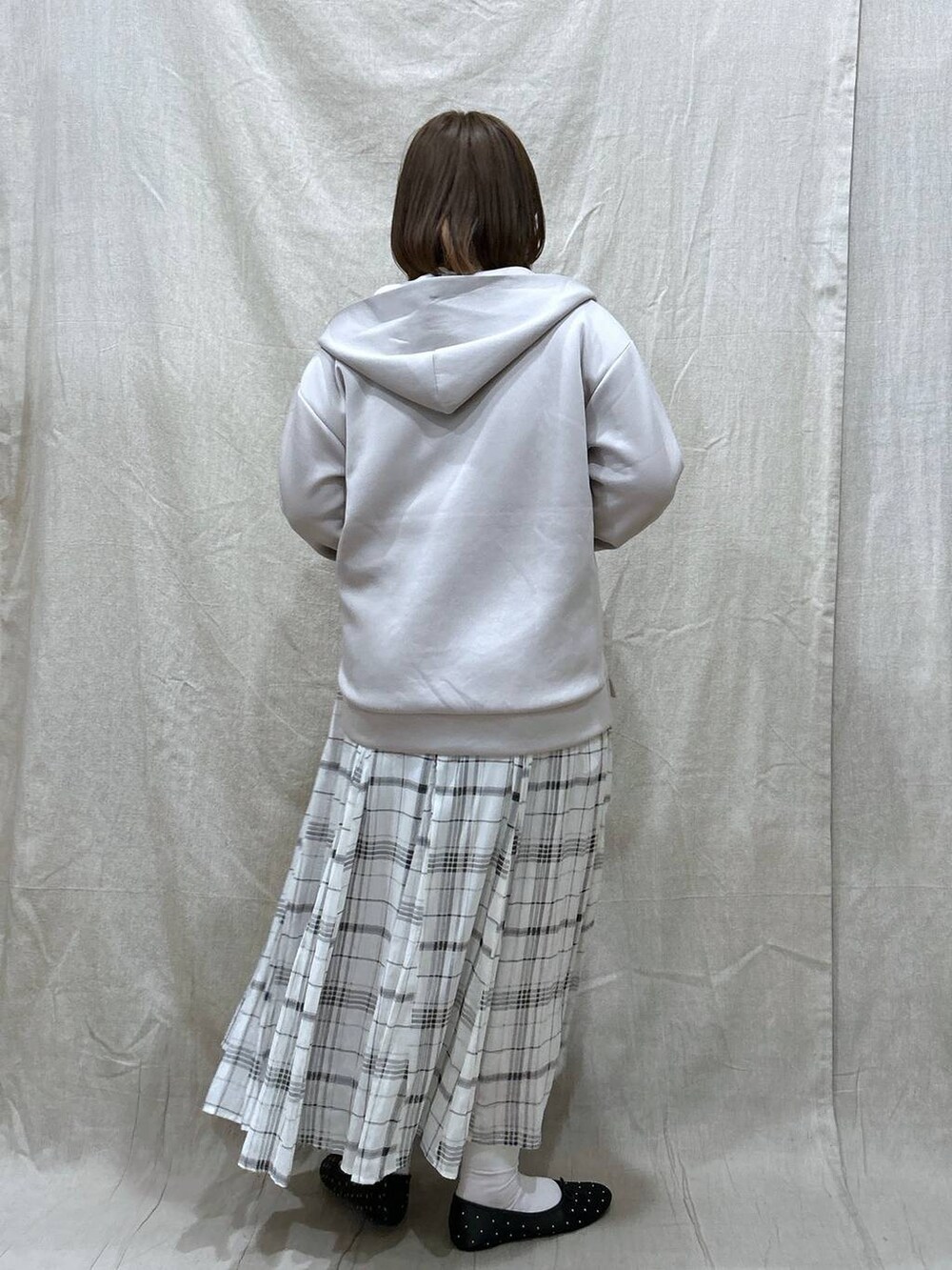 ベージュ系のスカート、ホワイト系のTシャツ/カットソー、ベージュ系のパーカーを着用したレディースの冬コーディネートの3枚目の写真