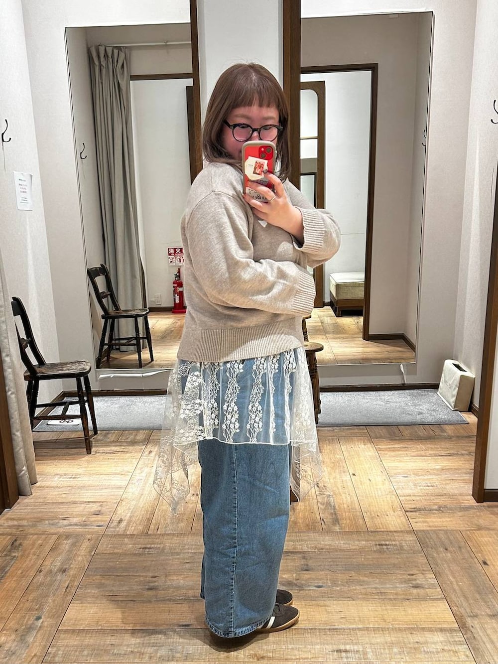 ブルー系のデニムパンツ、イエロー系のワンピース、ホワイト系のその他トップスを着用したレディースの秋コーディネートの3枚目の写真