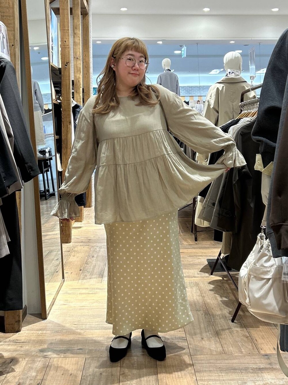 ベージュ系のスカート、ホワイト系のキャミソール、ブラック系のパンプスを着用したレディースの春コーディネートの4枚目の写真