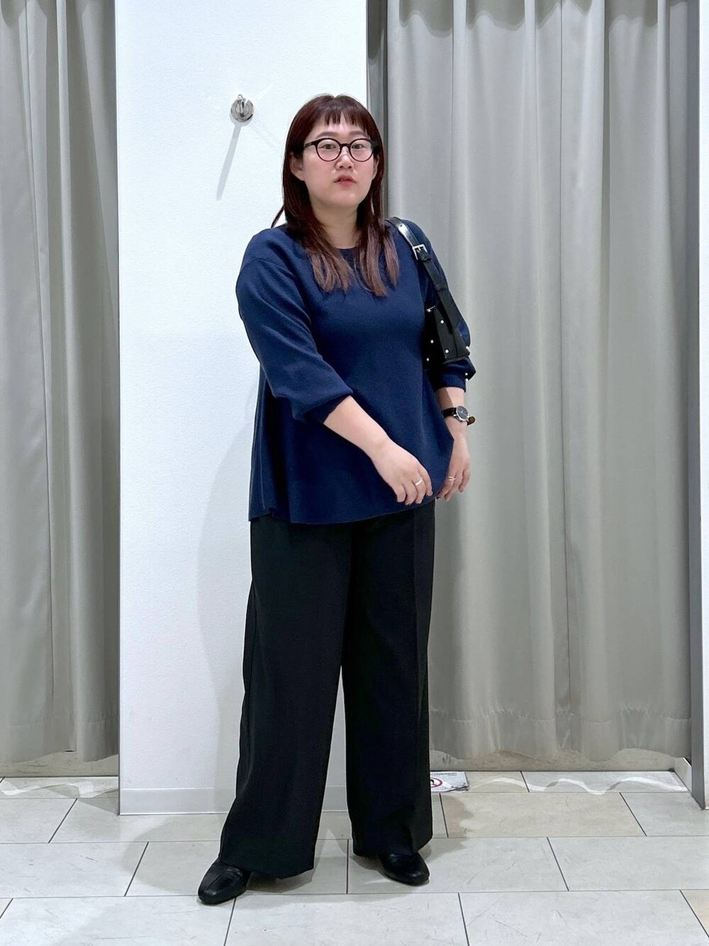 ブルー系のニット/セーター、ブラック系のその他パンツ、ブラック系のブーツを着用したレディースの秋コーディネートの2枚目の写真