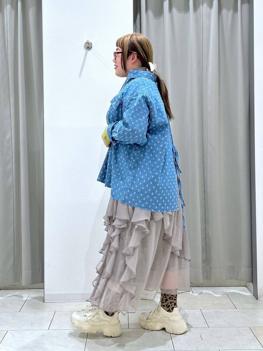 グレー系のニット/セーター、グレー系のスカート、ホワイト系のスニーカーを着用したレディースの冬コーディネートの4枚目の写真