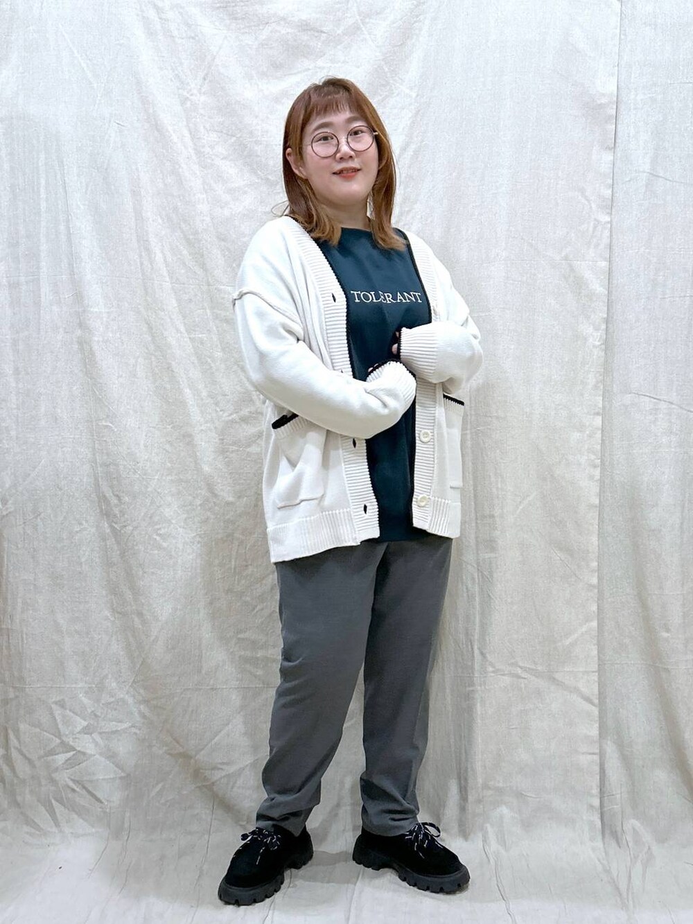 グレー系のその他パンツ、グリーン系のTシャツ/カットソー、ホワイト系のカーディガン/ボレロを着用したレディースの秋コーディネートの3枚目の写真