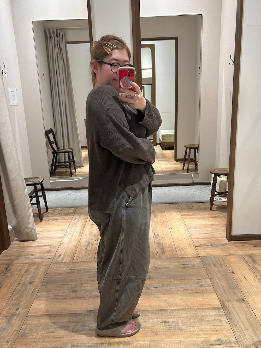 ブラウン系のデニムパンツ、ホワイト系のキャミソール、ベージュ系のサンダルを着用したレディースの秋コーディネートの2枚目の写真