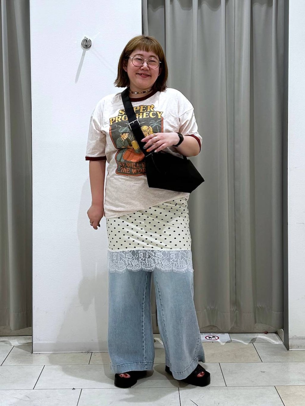 ブルー系のデニムパンツ、ブラック系のサンダル、ブラック系のショルダーバッグを着用したレディースの春コーディネートの3枚目の写真