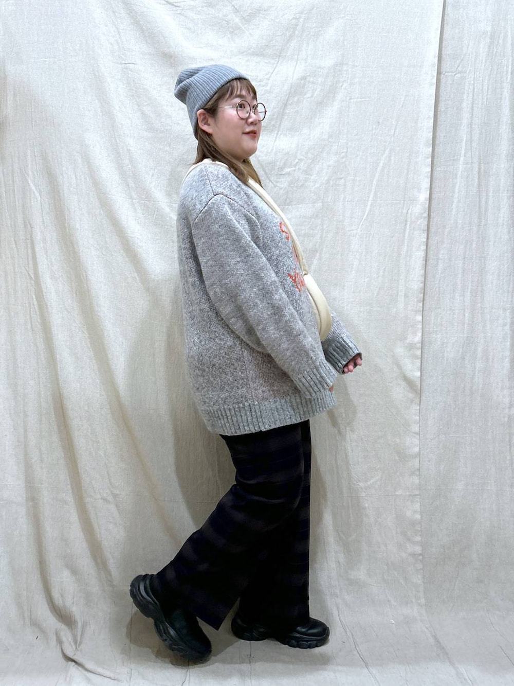 ホワイト系のショルダーバッグ、ブルー系のその他パンツ、ブラック系のブーツを着用したレディースの冬コーディネートの7枚目の写真