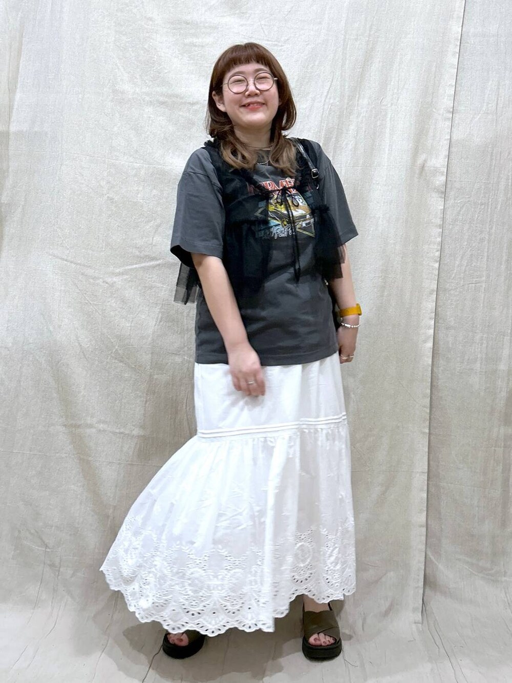 ホワイト系のスカート、グレー系のTシャツ/カットソー、グリーン系のサンダルを着用したレディースの夏コーディネートの2枚目の写真