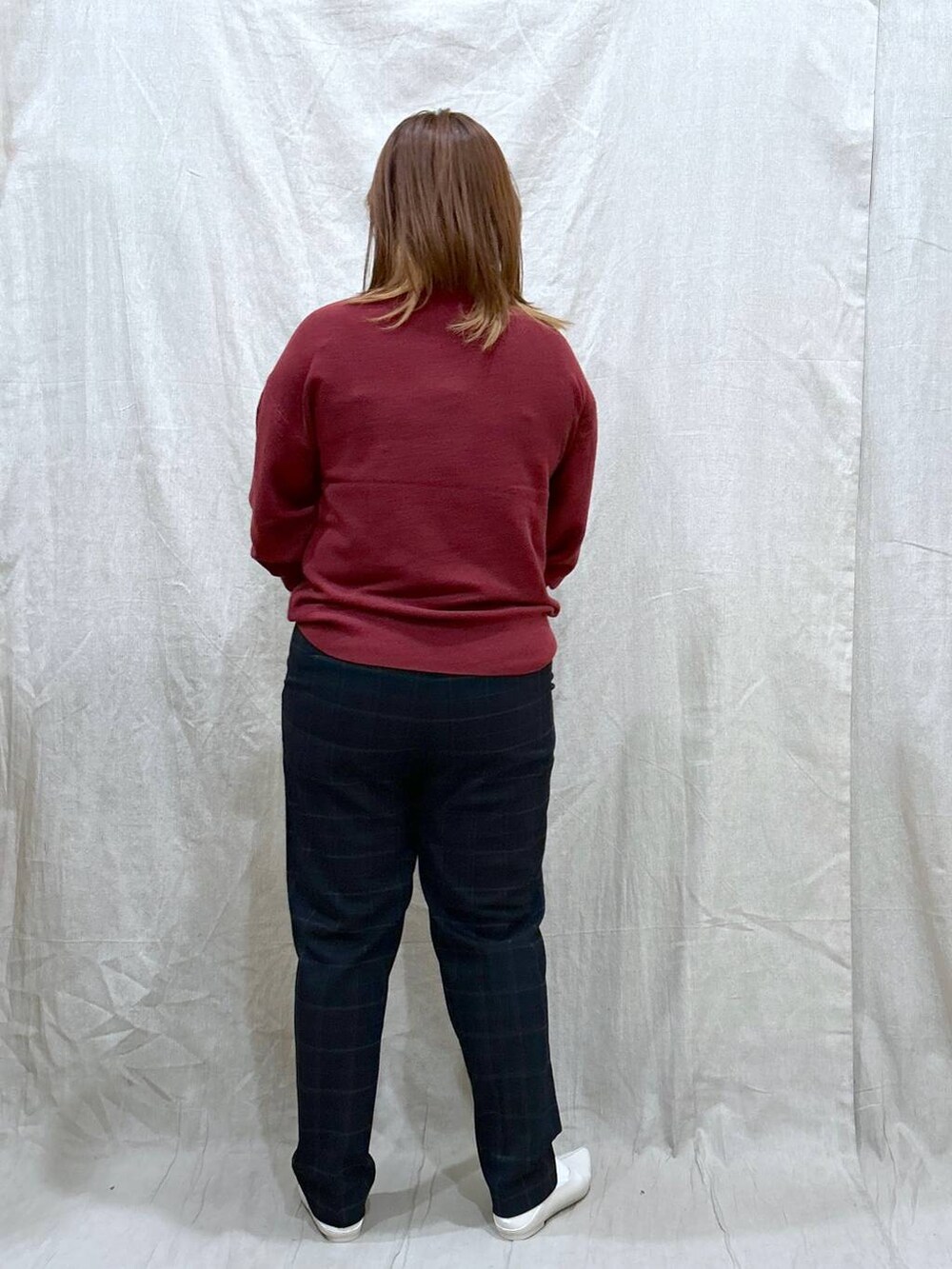 レッド系のニット/セーター、ブルー系のその他パンツ、ホワイト系のパンプスを着用したレディースの秋コーディネートの4枚目の写真