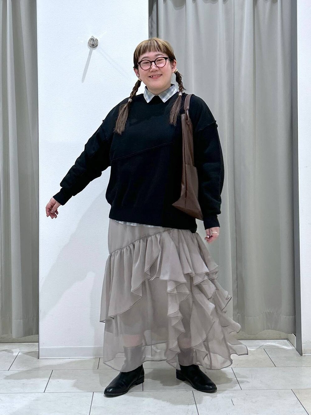 グリーン系のシャツ/ブラウス、ブラック系のブーツ、ブラウン系のトートバッグを着用したレディースの冬コーディネートの2枚目の写真