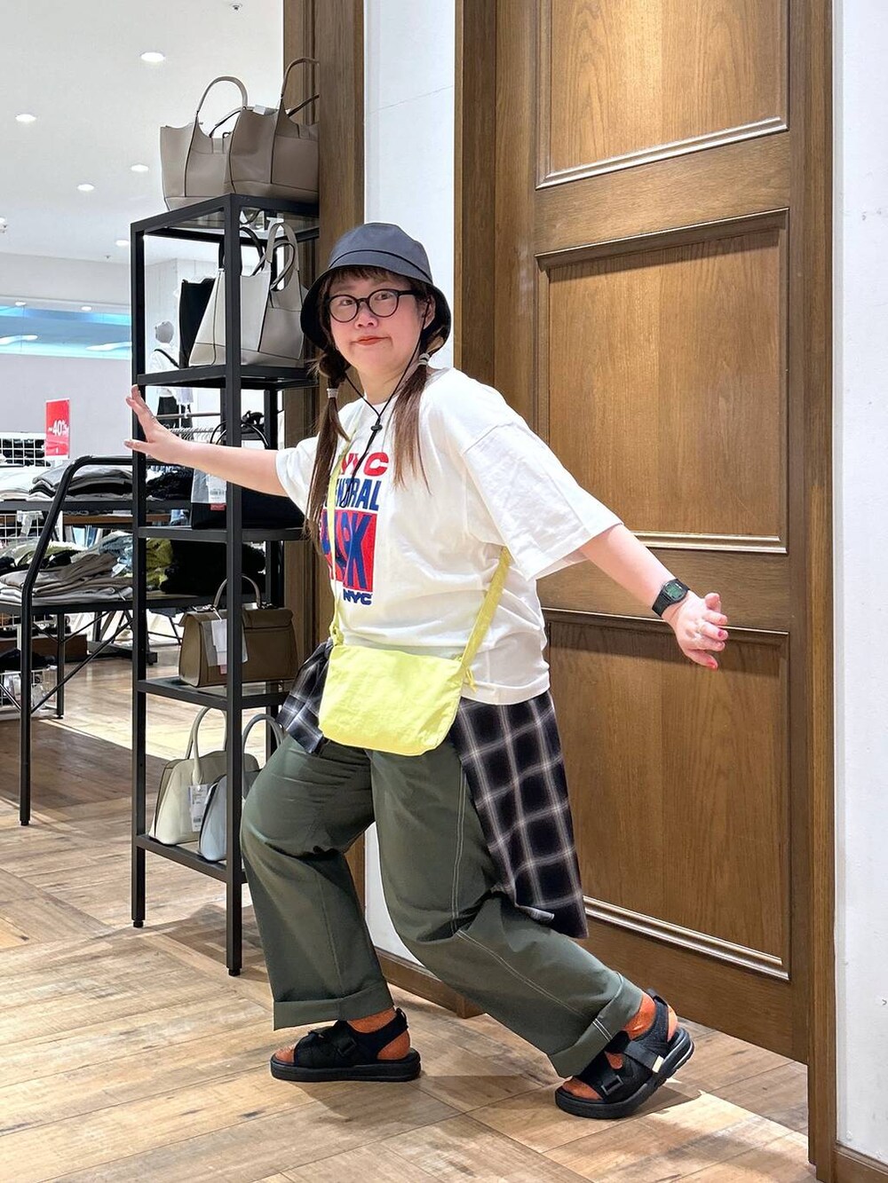 ブラック系のシャツ/ブラウス、グリーン系のその他パンツ、イエロー系のショルダーバッグを着用したレディースの春コーディネートの3枚目の写真