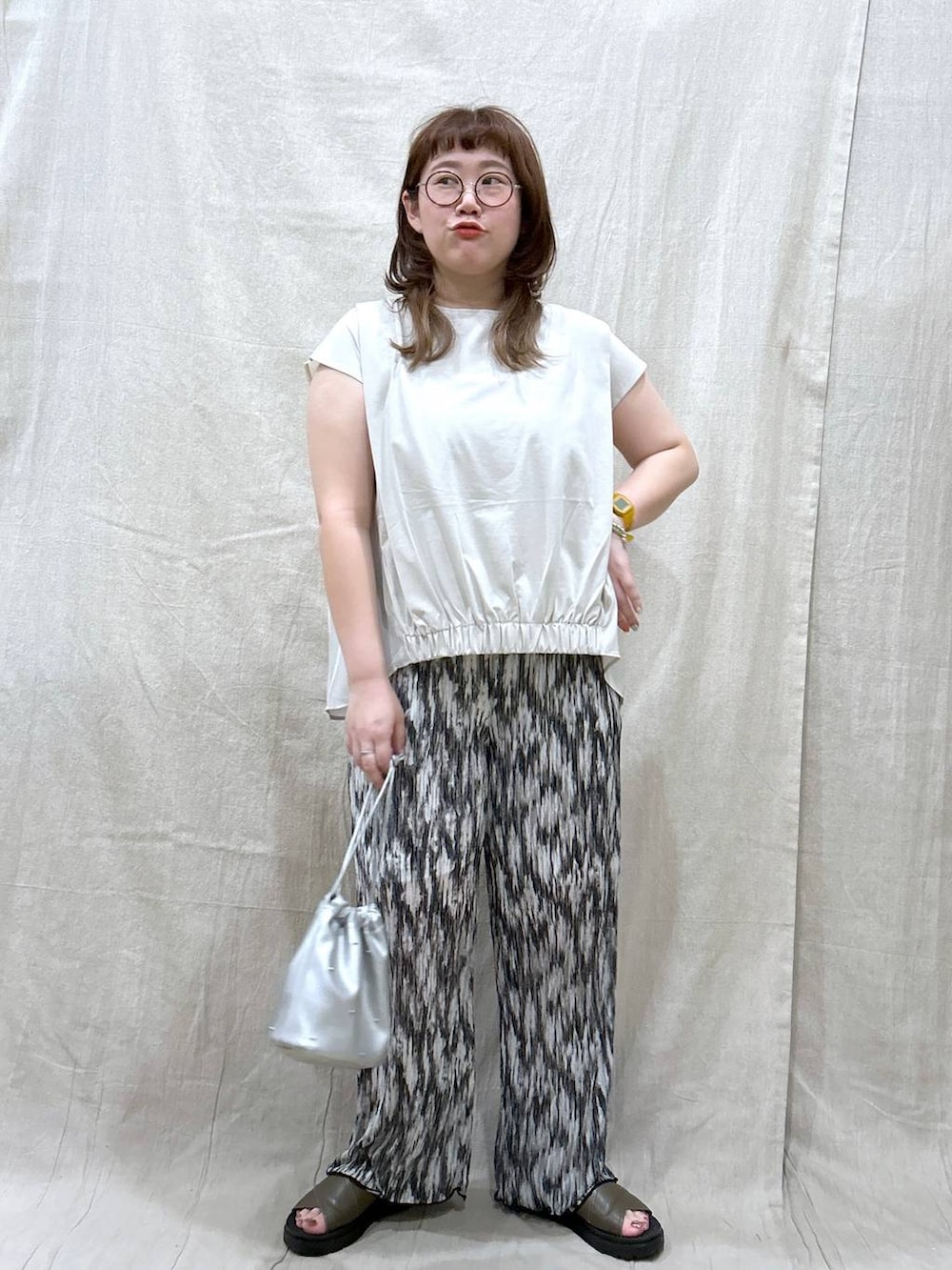 グリーン系のサンダル、シルバー系のショルダーバッグ、ブラック系のその他パンツを着用したレディースの夏コーディネートの2枚目の写真