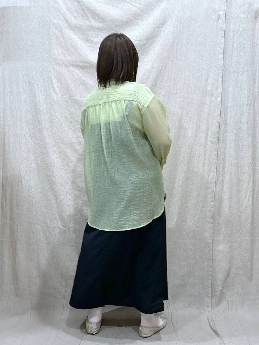 ホワイト系のタンクトップ、ブラック系のジャンパースカート、ホワイト系のバレエシューズを着用したレディースの春コーディネートの4枚目の写真