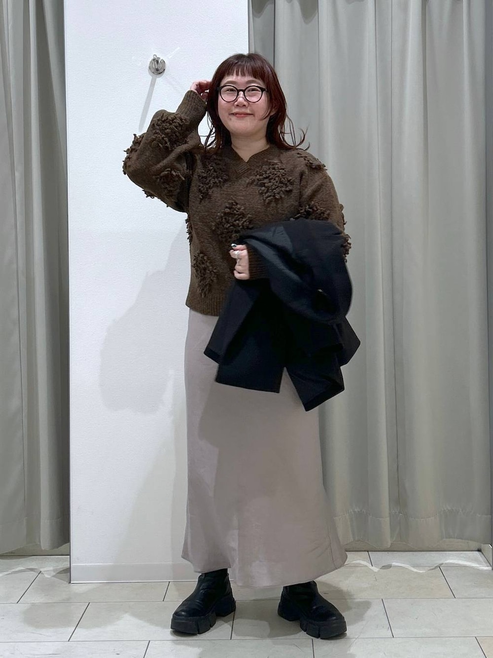 ブラック系のテーラードジャケット、グレー系のスカート、ブラウン系のショルダーバッグを着用したレディースの冬コーディネートの6枚目の写真