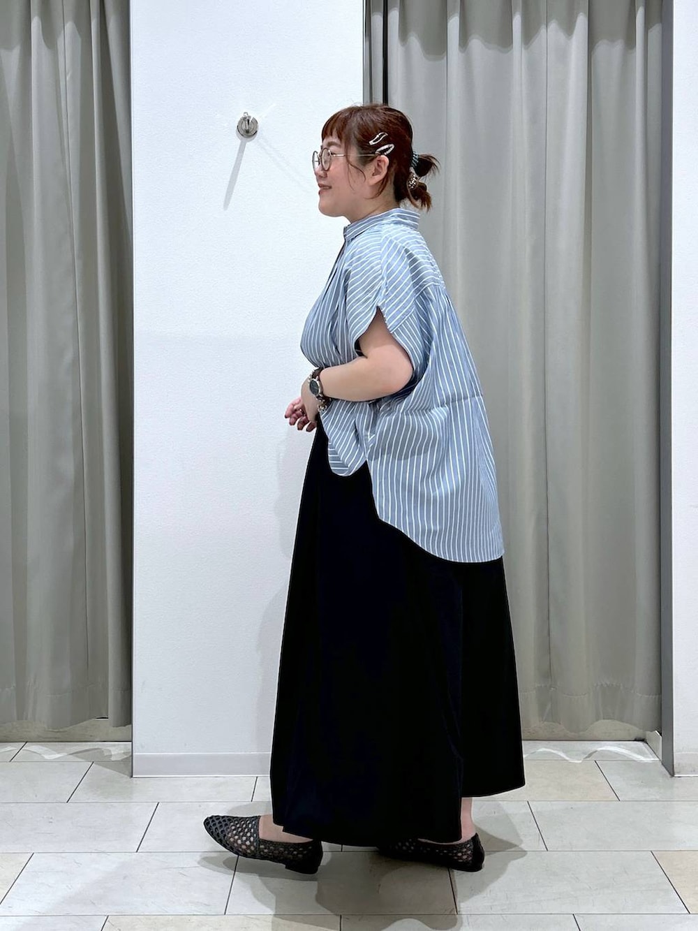 ブラック系のスカート、ブラック系のパンプス、ブルー系のシャツ/ブラウスを着用したレディースの夏コーディネートの4枚目の写真