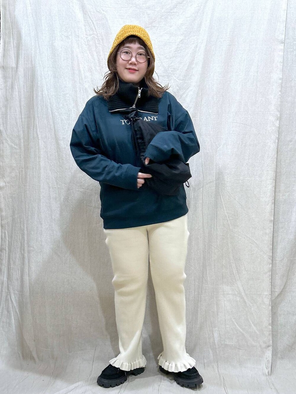 グリーン系のTシャツ/カットソー、ブラック系のモカシン/デッキシューズ、ブラック系のショルダーバッグを着用したレディースの秋コーディネートの4枚目の写真