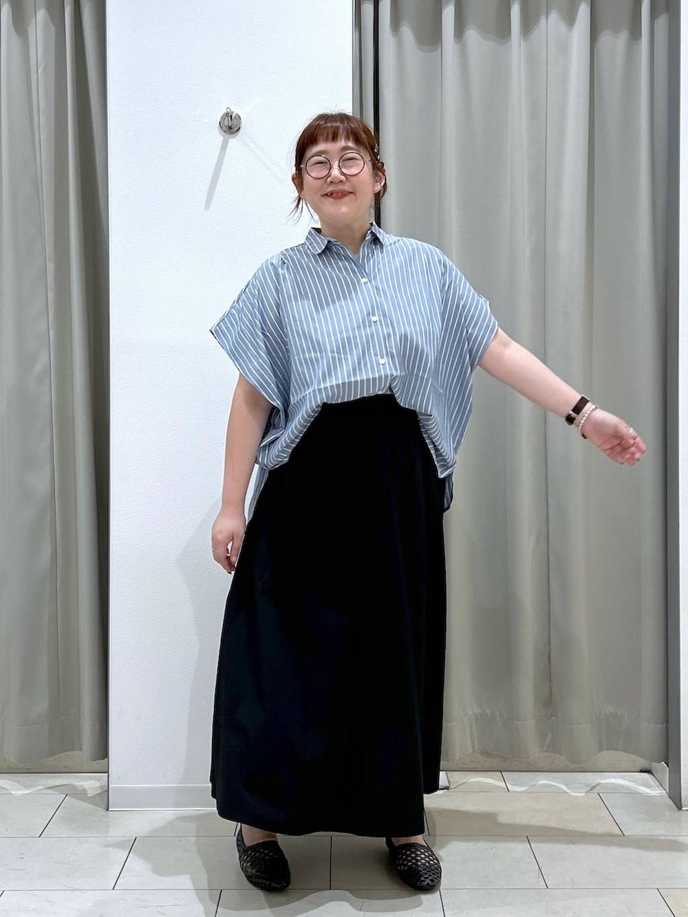 ブラック系のスカート、ブラック系のパンプス、ブルー系のシャツ/ブラウスを着用したレディースの夏コーディネートの3枚目の写真