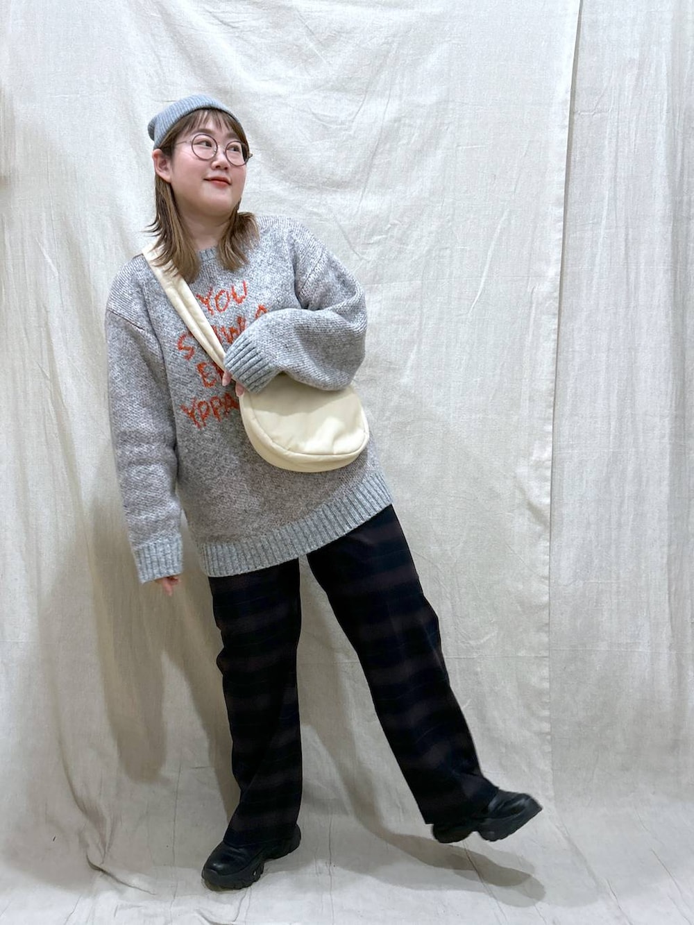 ホワイト系のショルダーバッグ、ブルー系のその他パンツ、ブラック系のブーツを着用したレディースの冬コーディネートの2枚目の写真