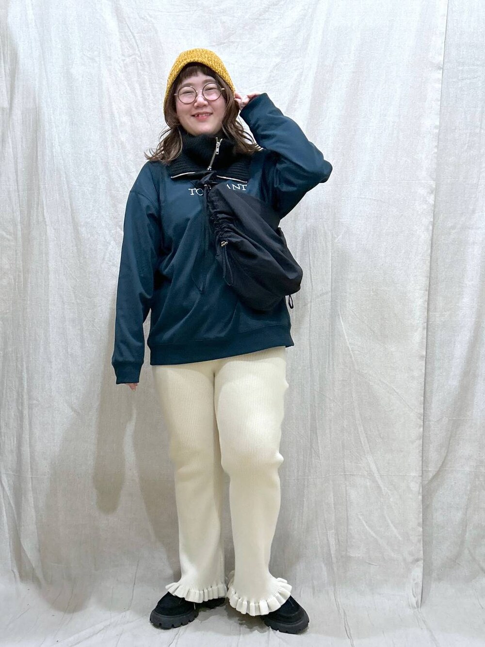 グリーン系のTシャツ/カットソー、ブラック系のモカシン/デッキシューズ、ブラック系のショルダーバッグを着用したレディースの秋コーディネートの2枚目の写真