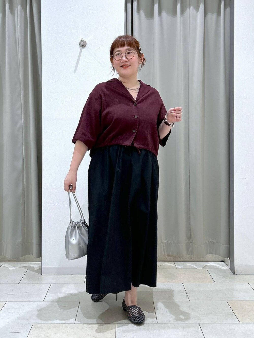 ブラック系のスカート、シルバー系のショルダーバッグ、ブラウン系のシャツ/ブラウスを着用したレディースの夏コーディネートの2枚目の写真