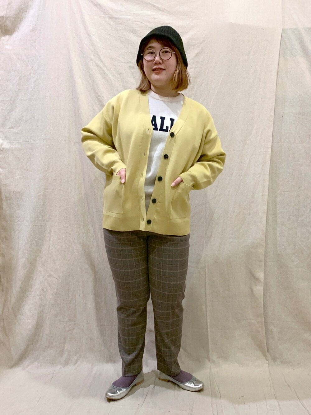 ホワイト系のニット/セーター、イエロー系のカーディガン/ボレロ、グレー系のその他パンツを着用したレディースの冬コーディネートの2枚目の写真