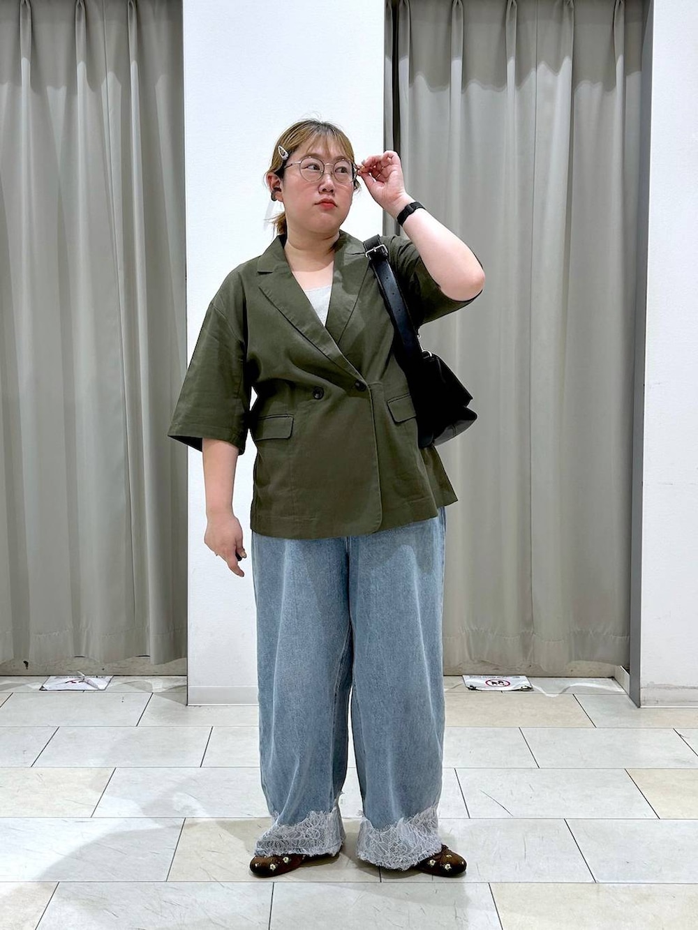 ブルー系のデニムパンツ、ブラック系のショルダーバッグ、ブラウン系のバレエシューズを着用したレディースの夏コーディネートの4枚目の写真